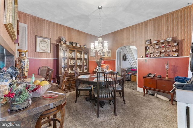 dining room with carpet flooring and a notable chandelier