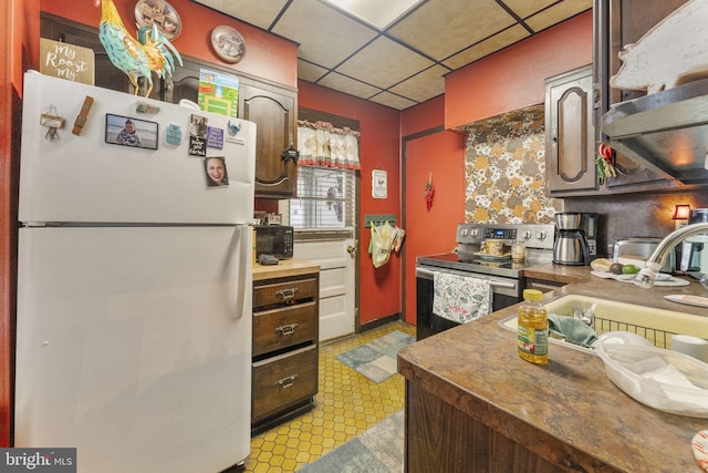 kitchen with white refrigerator, dark brown cabinets, a drop ceiling, and electric stove