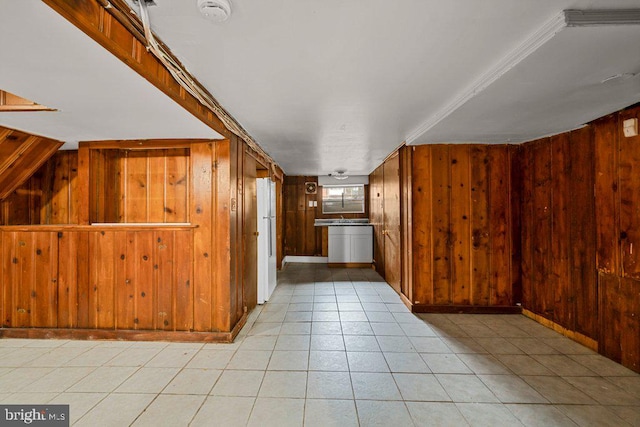 hallway featuring light tile patterned floors and wood walls