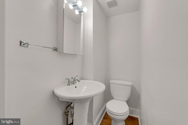 bathroom with hardwood / wood-style flooring and toilet