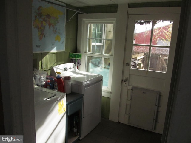 clothes washing area with washer and dryer and a healthy amount of sunlight