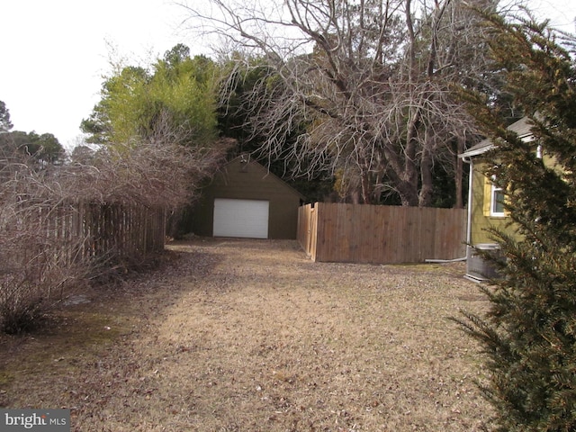 view of yard featuring a garage and an outbuilding