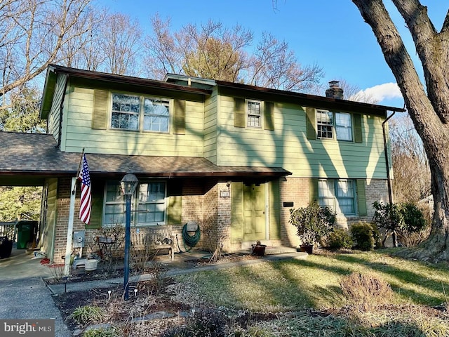 view of front of property with a shingled roof, brick siding, driveway, and a chimney