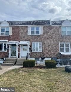 townhome / multi-family property featuring a front lawn