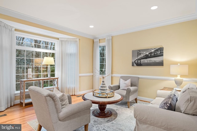 living room with crown molding, a wealth of natural light, and hardwood / wood-style floors