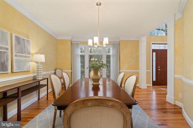 dining area featuring hardwood / wood-style floors, ornamental molding, and a chandelier