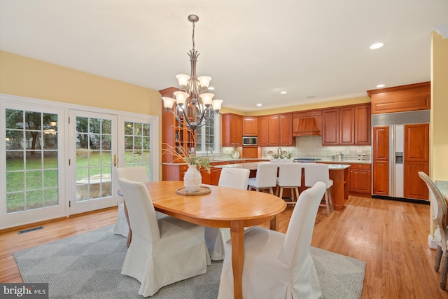 dining room featuring a chandelier and light wood-type flooring