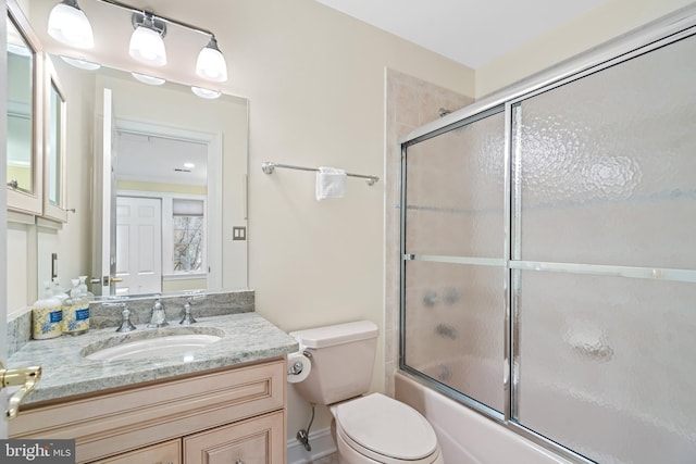 full bathroom featuring vanity, toilet, and combined bath / shower with glass door