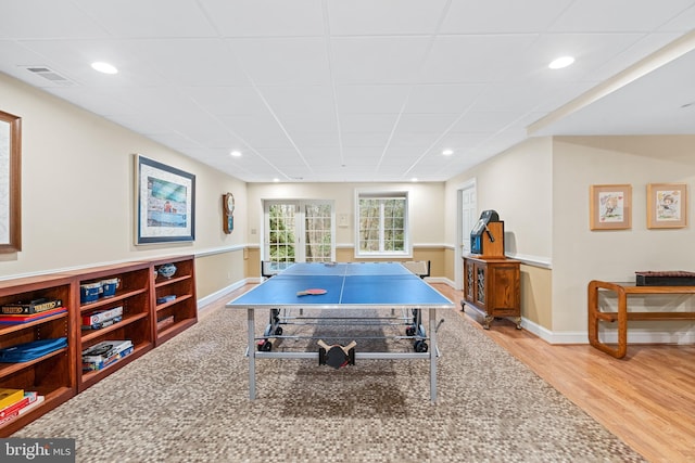 playroom featuring wood-type flooring and a paneled ceiling