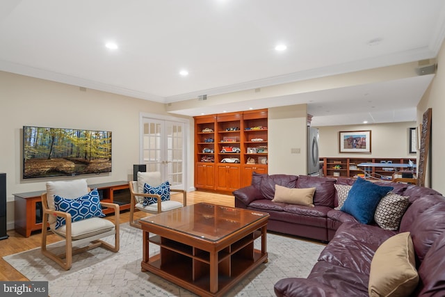 living room featuring light hardwood / wood-style flooring, ornamental molding, and french doors