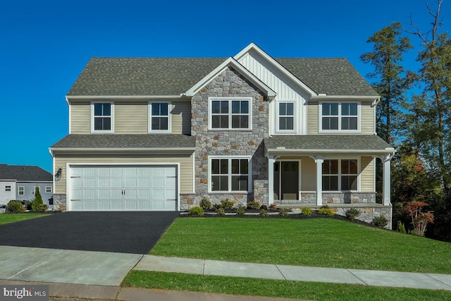 craftsman-style house with aphalt driveway, an attached garage, a porch, board and batten siding, and a front yard