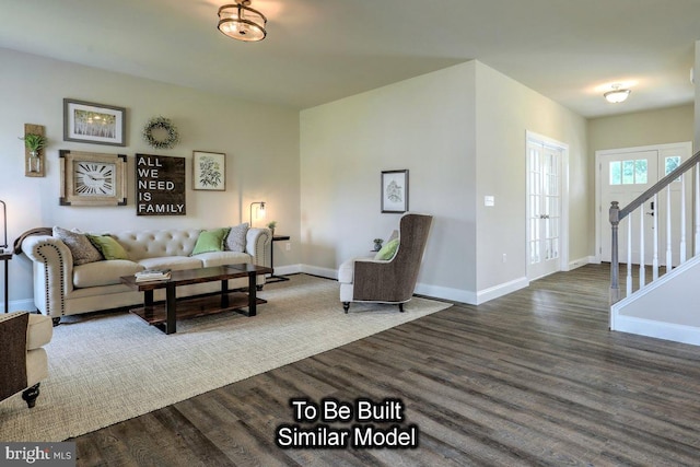 living area featuring stairs, wood finished floors, and baseboards