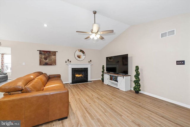 living room featuring vaulted ceiling, ceiling fan, and light hardwood / wood-style flooring