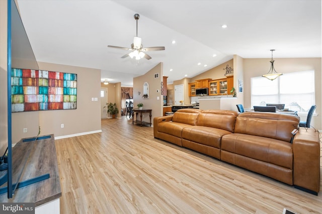 living room featuring ceiling fan, lofted ceiling, and light wood-type flooring