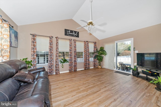 living room with ceiling fan, lofted ceiling, and light hardwood / wood-style floors