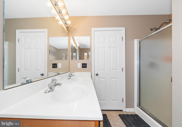 bathroom featuring a shower with door, vanity, and tile patterned floors