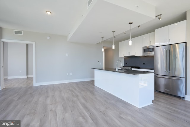 kitchen featuring decorative light fixtures, white cabinetry, sink, decorative backsplash, and stainless steel appliances