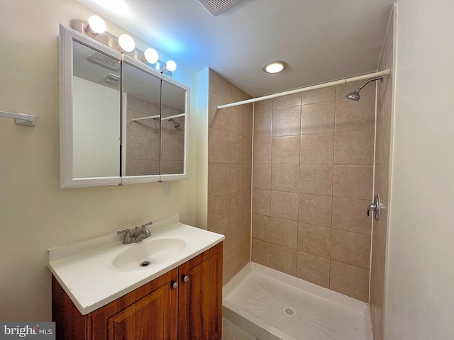 bathroom with vanity and a tile shower