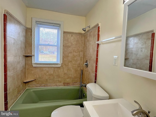 full bathroom with tiled shower / bath, toilet, and sink