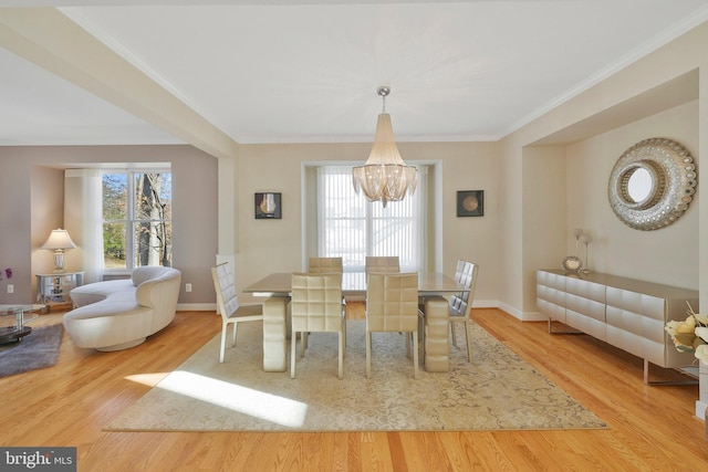 dining space featuring ornamental molding, plenty of natural light, light hardwood / wood-style floors, and a notable chandelier