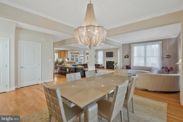 dining space with crown molding and light wood-type flooring