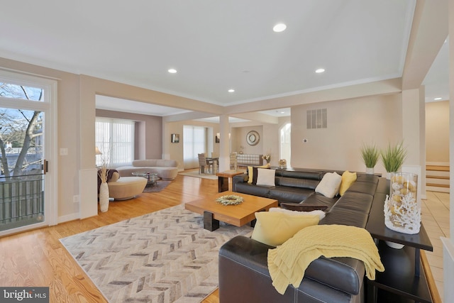 living room featuring crown molding and light hardwood / wood-style flooring