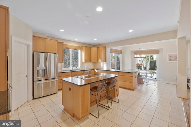 kitchen featuring light tile patterned flooring, a breakfast bar area, stainless steel fridge, kitchen peninsula, and a kitchen island