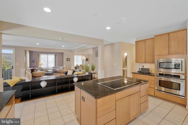 kitchen with a center island, stainless steel appliances, light brown cabinetry, and light tile patterned floors