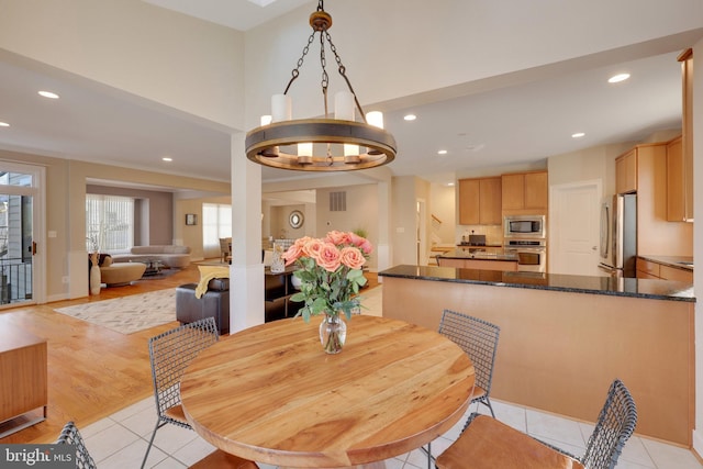 tiled dining space with a notable chandelier