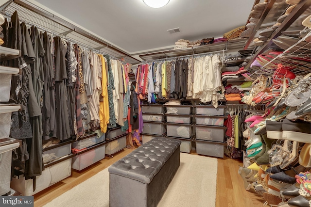 walk in closet with light hardwood / wood-style flooring