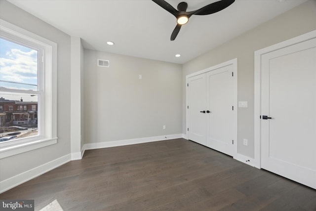 unfurnished bedroom with dark hardwood / wood-style flooring and ceiling fan