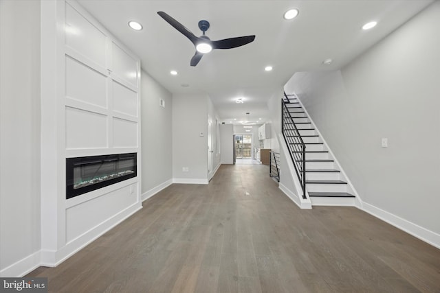 unfurnished living room featuring ceiling fan and wood-type flooring