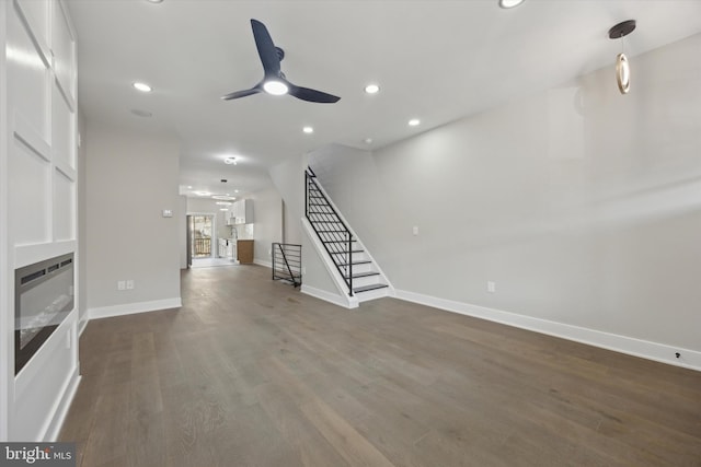 unfurnished living room with ceiling fan and dark hardwood / wood-style floors