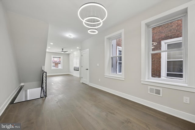 corridor with a notable chandelier and dark hardwood / wood-style floors