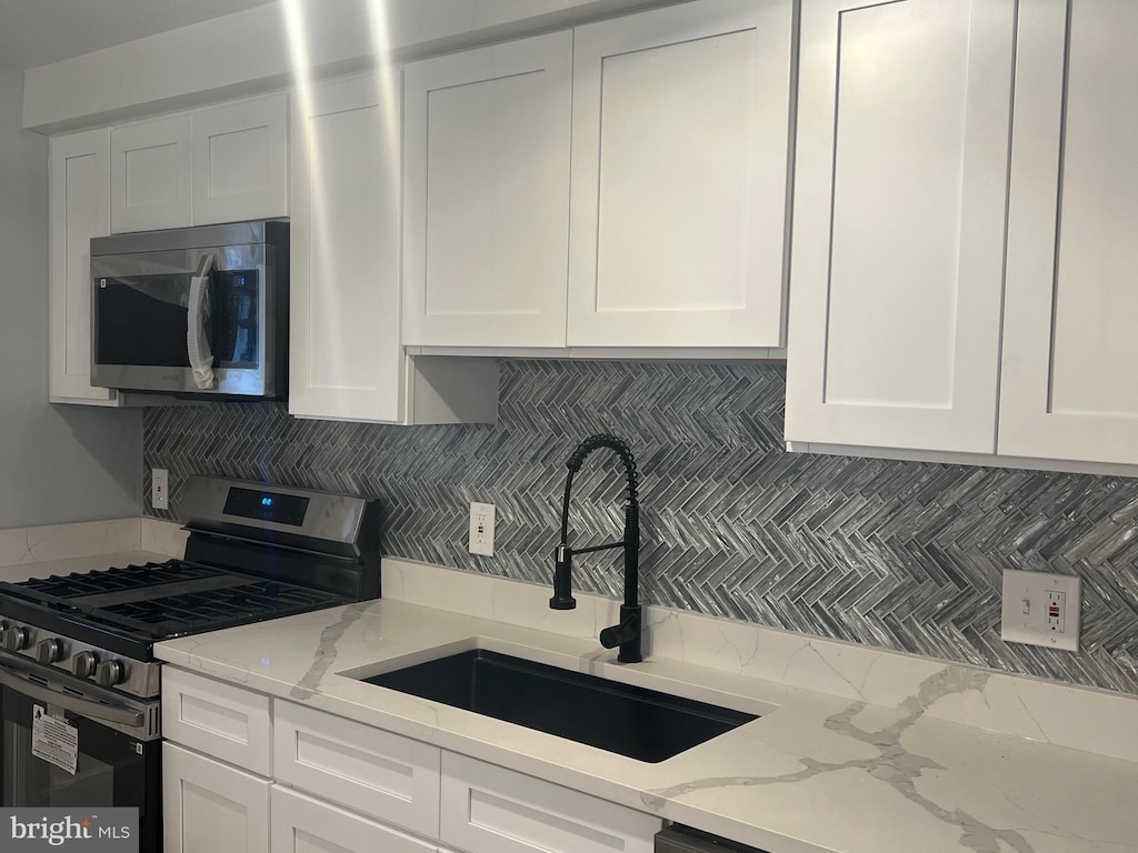 kitchen featuring white cabinetry, appliances with stainless steel finishes, and sink