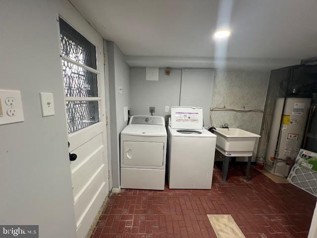 washroom with sink, washing machine and dryer, and water heater