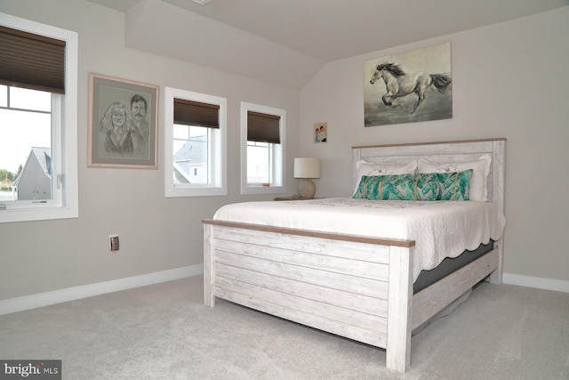 carpeted bedroom featuring baseboards and lofted ceiling