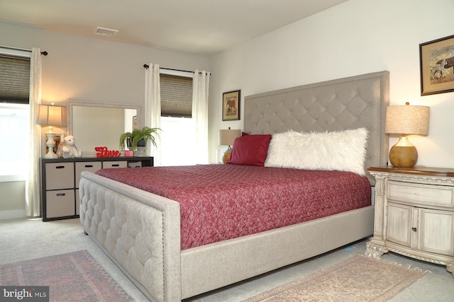 bedroom featuring visible vents and light carpet
