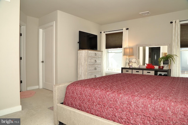 bedroom with visible vents, carpet, baseboards, and multiple windows