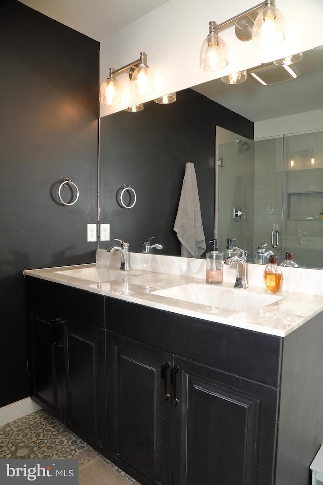 full bathroom with a sink, a shower stall, and double vanity