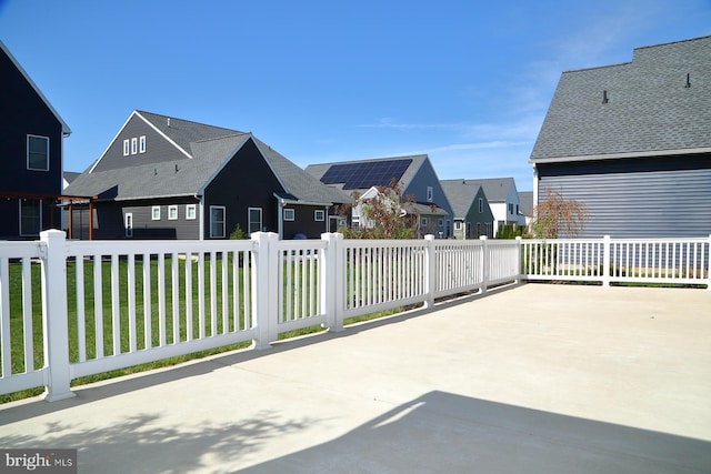 view of patio featuring fence and a residential view