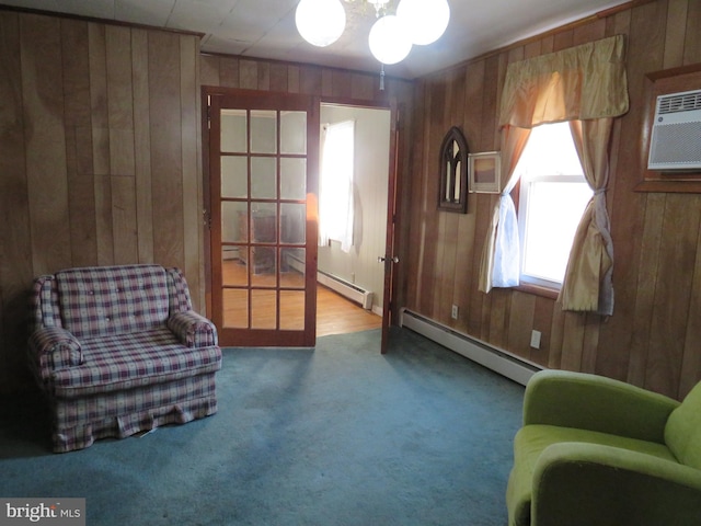 living area with a baseboard radiator, wooden walls, and carpet flooring