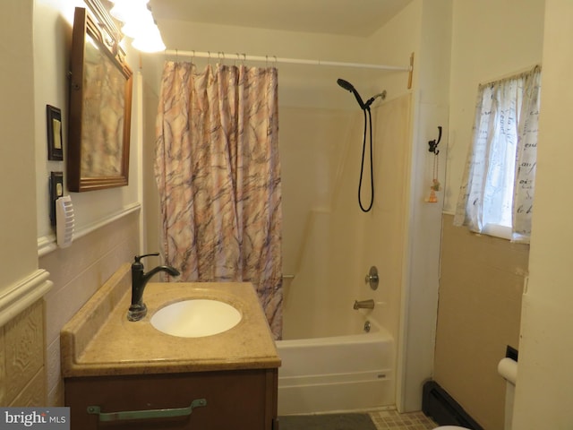 bathroom with shower / bath combo, tile walls, and vanity