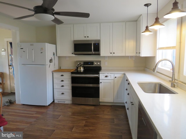 kitchen with white cabinetry, appliances with stainless steel finishes, sink, and decorative light fixtures