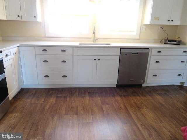 kitchen with stainless steel dishwasher, sink, and white cabinets