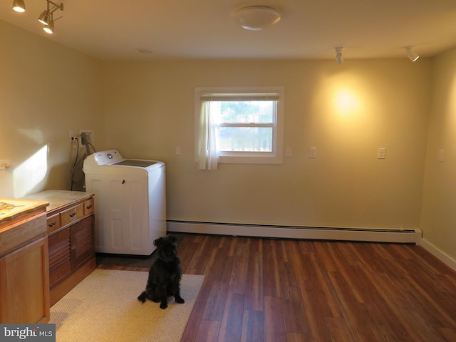 clothes washing area with dark hardwood / wood-style floors, washer / dryer, and a baseboard heating unit