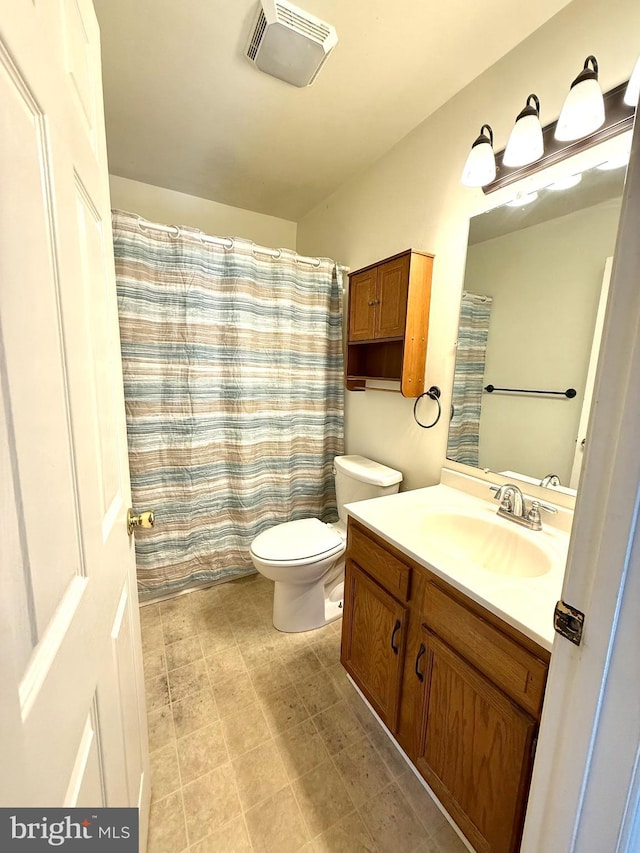 bathroom featuring a shower with curtain, vanity, and toilet