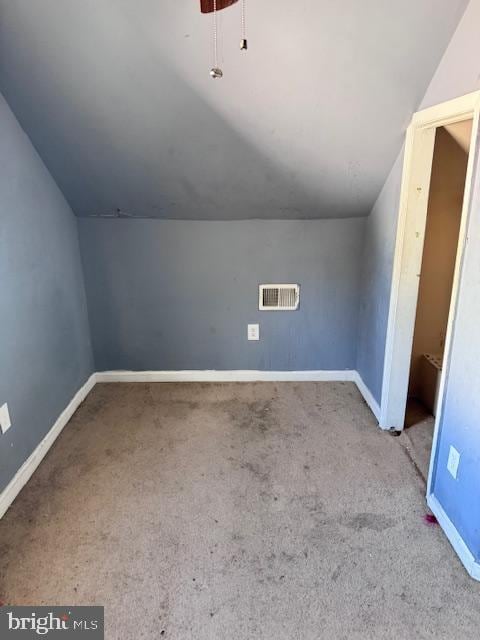 bonus room with vaulted ceiling and light carpet