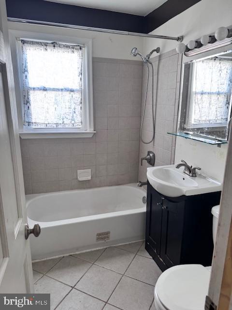 full bathroom with tile patterned floors, toilet, tiled shower / bath combo, and vanity