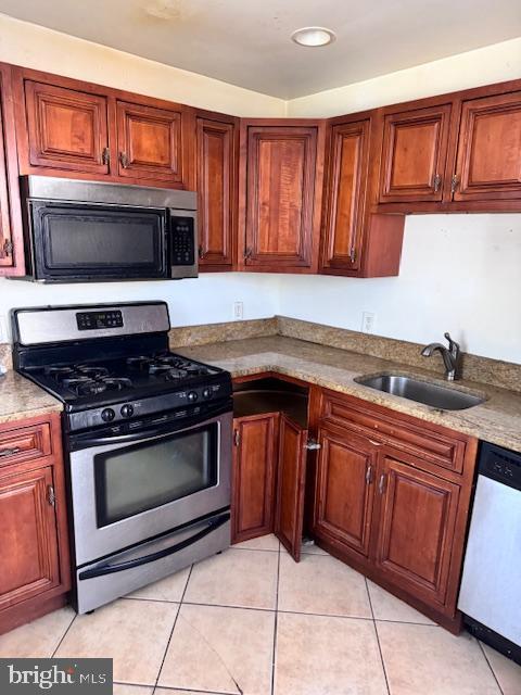 kitchen with sink, light tile patterned floors, and appliances with stainless steel finishes